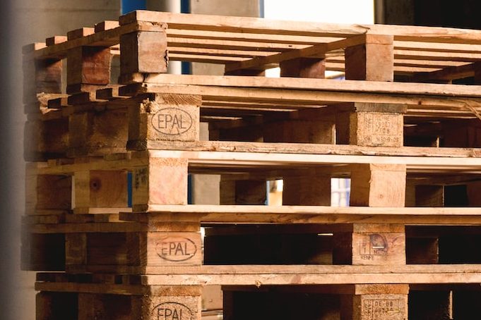 selective focus photography of piled brown wooden pallets
